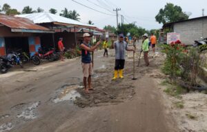 Perangkat Desa dan Masyarakat Margo Mulyo Gotong-royong Timbun Jalan Rusak